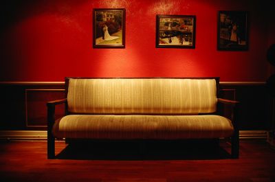 An antique yellow couch in a red room